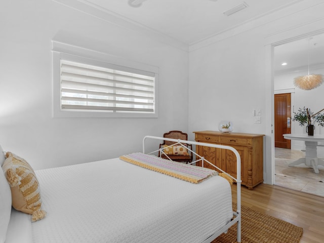bedroom featuring wood finished floors and crown molding