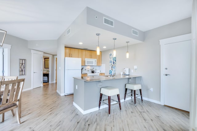 9800 Grand Sandestin Blvd Unit 5410/5412, Miramar Beach, FL 32550 - kitchen featuring white appliances, a sink, a peninsula, a kitchen breakfast bar, and light wood-type flooring