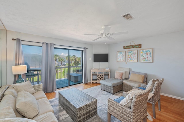 living room featuring a ceiling fan, wood finished floors, and baseboards