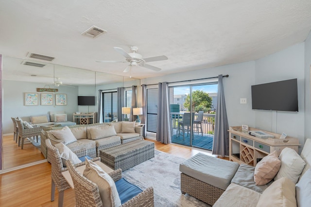 living area with ceiling fan and light wood-style flooring