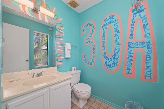 bathroom featuring toilet, vanity, and tile patterned floors