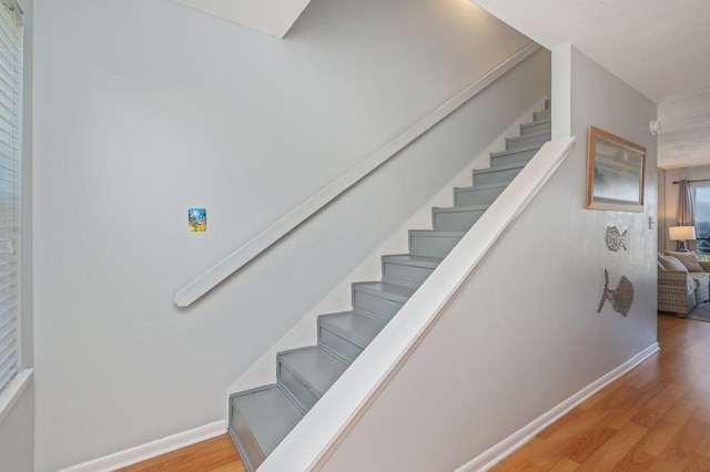 stairway featuring wood finished floors and baseboards