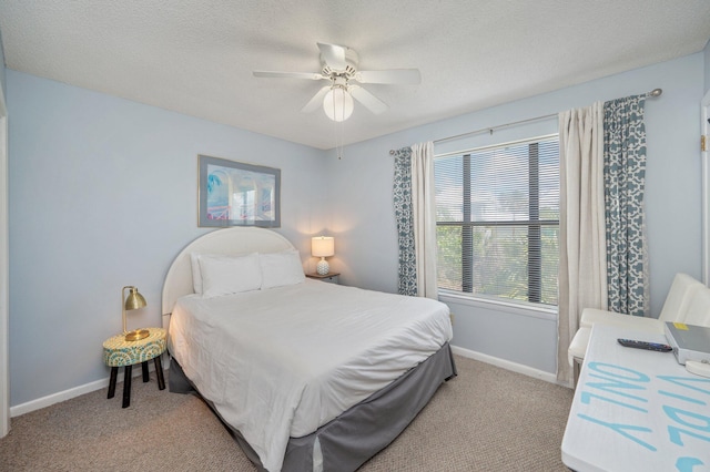 bedroom with light colored carpet, baseboards, a ceiling fan, and a textured ceiling