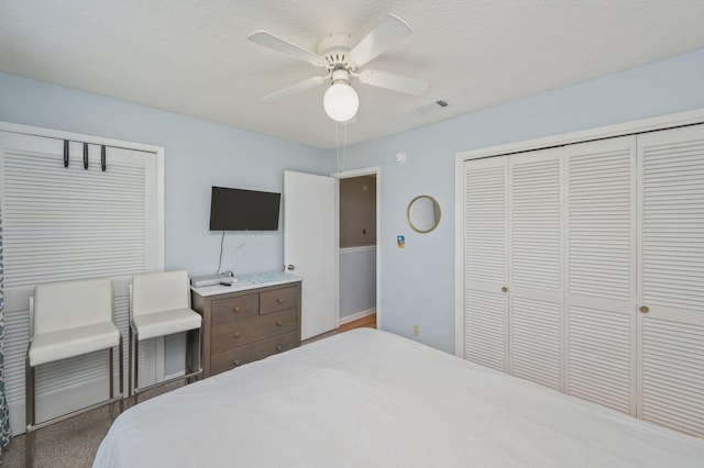 bedroom with a closet, a ceiling fan, a textured ceiling, and baseboards