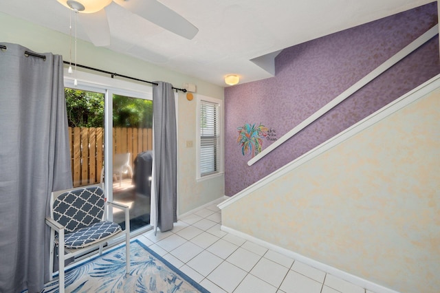 doorway to outside featuring tile patterned floors, baseboards, and ceiling fan
