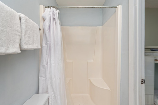 full bath with a shower stall and toilet