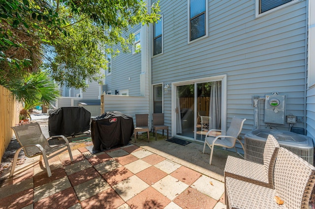 view of patio with central AC unit, fence, and area for grilling