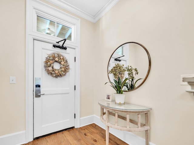 entrance foyer with crown molding, light wood finished floors, and baseboards