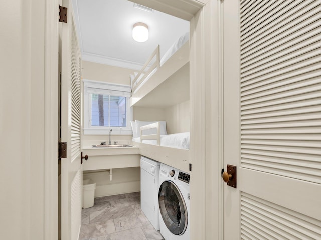 laundry area with washer / dryer, ornamental molding, a sink, and light marble finish floors