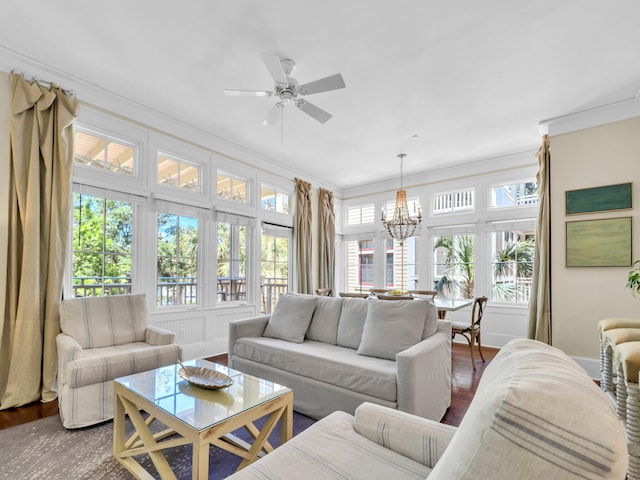living area with a chandelier, ornamental molding, dark wood finished floors, and ceiling fan