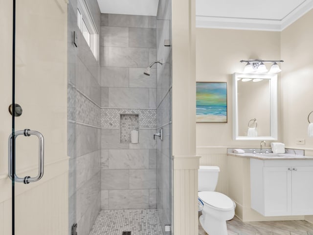 full bathroom with toilet, a shower stall, vanity, ornamental molding, and a wainscoted wall