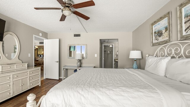 bedroom with a textured ceiling, dark wood finished floors, connected bathroom, and a ceiling fan