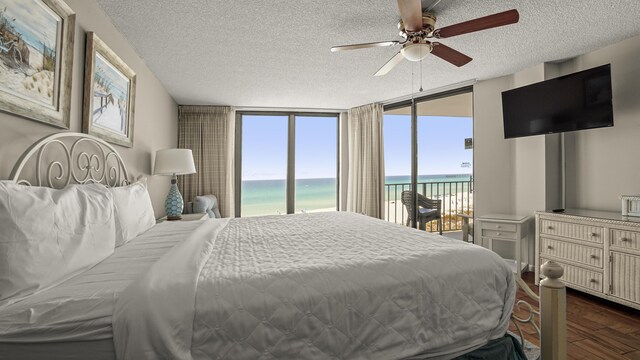 bedroom with access to outside, dark wood-type flooring, a textured ceiling, and ceiling fan
