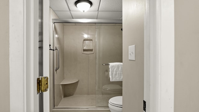 full bath featuring toilet, a stall shower, and a paneled ceiling