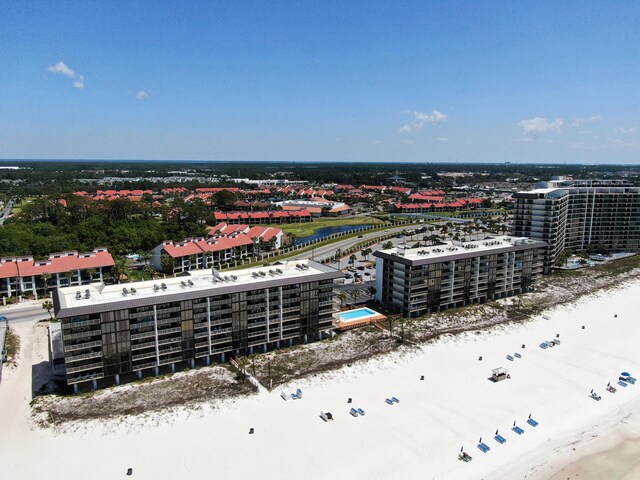 bird's eye view of waterfront with a beach and apartment complex