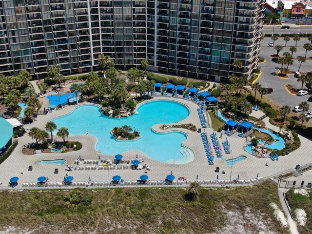 drone / aerial view of a pool area and apartment complex
