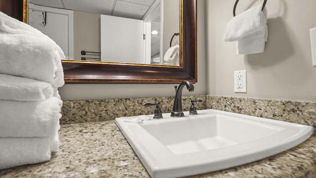 bathroom featuring a sink and a drop ceiling