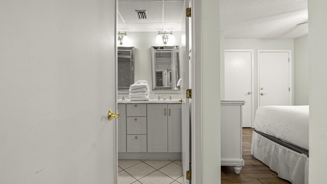bathroom featuring a textured ceiling, vanity, and baseboards