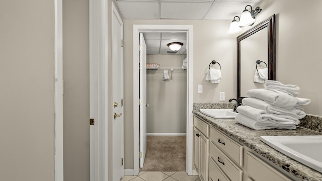 bathroom featuring a drop ceiling, tile patterned flooring, and double vanity