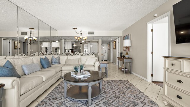 living area with a chandelier, light tile patterned floors, and a textured ceiling