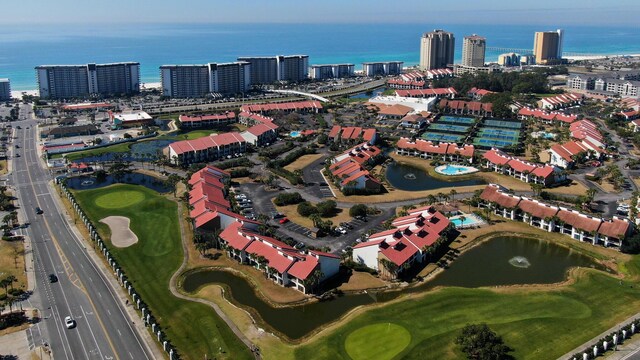 aerial overview of property's location with a large body of water, a golf course, and nearby urban area