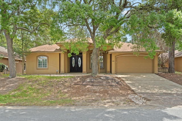 1049 Napa Way, Niceville, FL 32578 - view of front of property with an attached garage, driveway, stucco siding, and french doors
