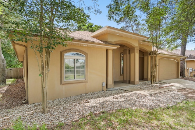 1049 Napa Way, Niceville, FL 32578 - mediterranean / spanish-style home featuring an attached garage, driveway, roof with shingles, and stucco siding