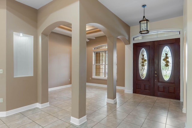 1049 Napa Way, Niceville, FL 32578 - foyer entrance featuring arched walkways, light tile patterned flooring, beam ceiling, and baseboards