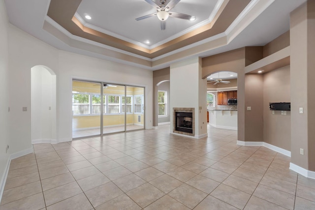 1049 Napa Way, Niceville, FL 32578 - unfurnished living room with a ceiling fan, ornamental molding, a raised ceiling, light tile patterned floors, and arched walkways
