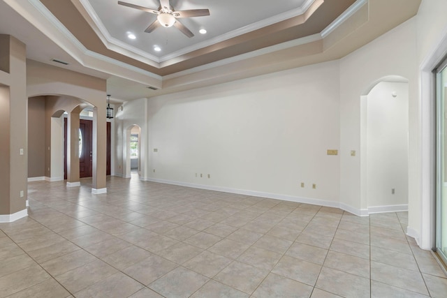 1049 Napa Way, Niceville, FL 32578 - spare room with arched walkways, a ceiling fan, light tile patterned flooring, a tray ceiling, and crown molding