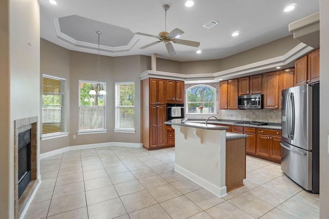 1049 Napa Way, Niceville, FL 32578 - kitchen with appliances with stainless steel finishes, light tile patterned floors, backsplash, ceiling fan, and a fireplace
