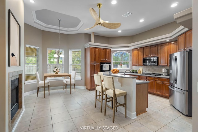 1049 Napa Way, Niceville, FL 32578 - kitchen with stainless steel appliances, a tray ceiling, light tile patterned flooring, plenty of natural light, and recessed lighting