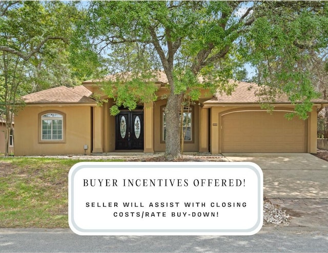 1049 Napa Way, Niceville, FL 32578 - view of front facade with a garage, driveway, stucco siding, and a shingled roof