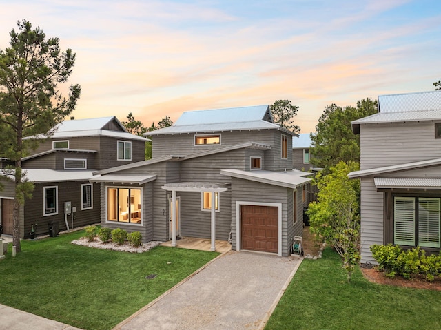contemporary home with a garage, gravel driveway, and a yard