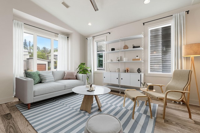 sitting room with lofted ceiling, healthy amount of natural light, light wood-type flooring, and recessed lighting
