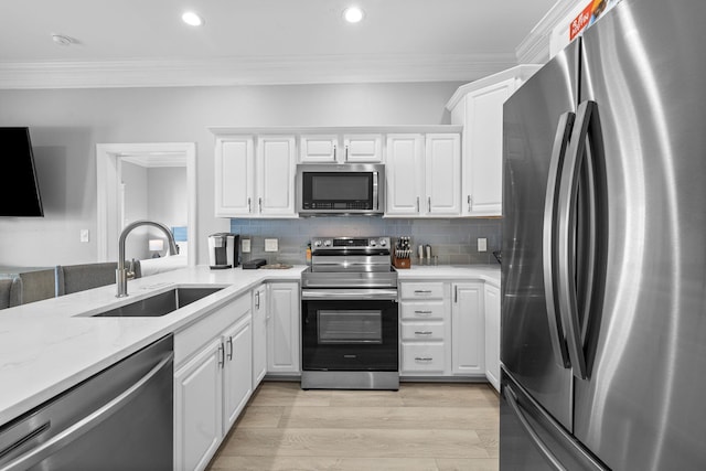 4724 Rendezvous Cv, Destin, FL 32541 - kitchen with appliances with stainless steel finishes, a sink, white cabinetry, ornamental molding, and recessed lighting