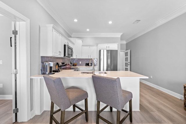 4724 Rendezvous Cv, Destin, FL 32541 - kitchen with stainless steel appliances, a sink, a peninsula, backsplash, and light wood-type flooring