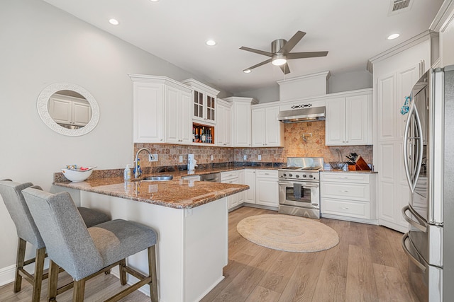 4724 Rendezvous Cv, Destin, FL 32541 - kitchen with stainless steel appliances, a sink, range hood, a peninsula, and ceiling fan