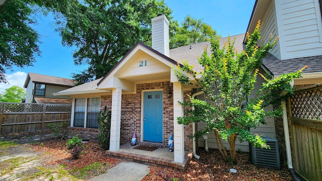 1100 Crosswinds Lndg Unit 21, Fort Walton Beach, FL 32547 - bungalow-style house featuring a shingled roof, fence, central air condition unit, and brick siding