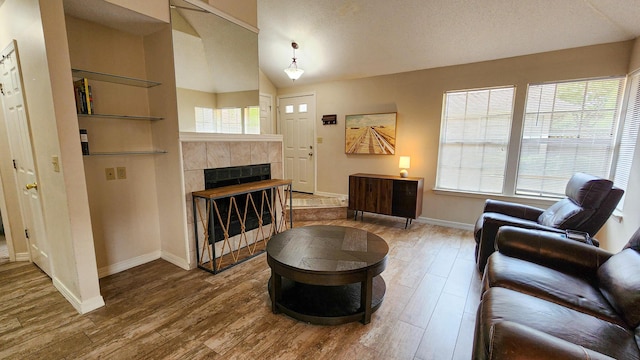 1100 Crosswinds Lndg Unit 21, Fort Walton Beach, FL 32547 - living room featuring wood finished floors, baseboards, vaulted ceiling, and a tiled fireplace