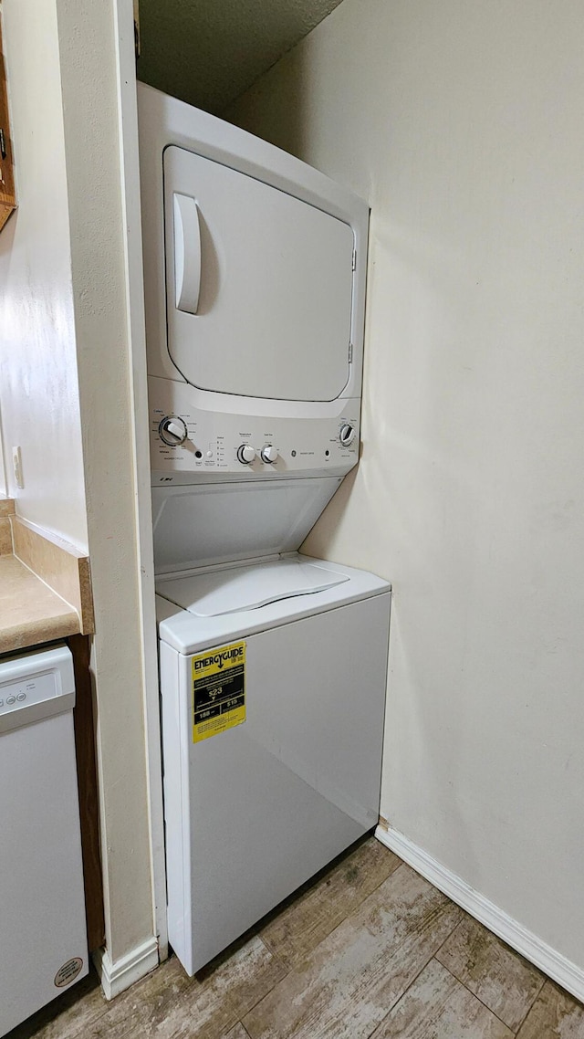 1100 Crosswinds Lndg Unit 21, Fort Walton Beach, FL 32547 - laundry area with stacked washing machine and dryer, light wood-type flooring, and baseboards