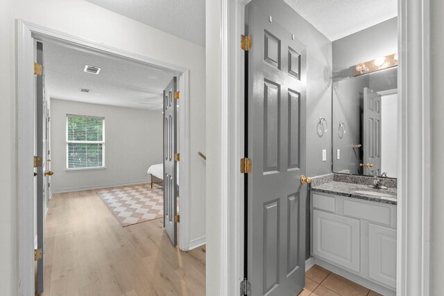 9 5th Ave, Shalimar, FL 32579 - bathroom featuring vanity, wood finished floors, a textured ceiling, and baseboards