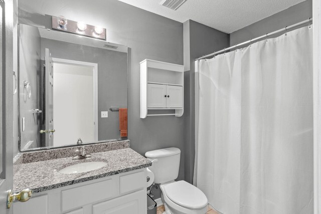 9 5th Ave, Shalimar, FL 32579 - bathroom featuring vanity, toilet, a textured ceiling, and a shower with curtain