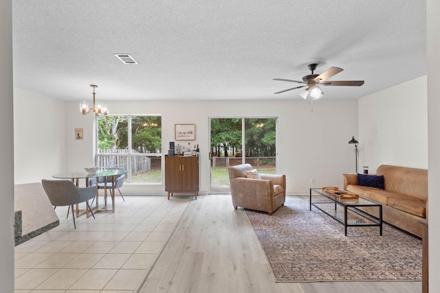 9 5th Ave, Shalimar, FL 32579 - living area with a chandelier, a ceiling fan, light wood-style floors, and a textured ceiling