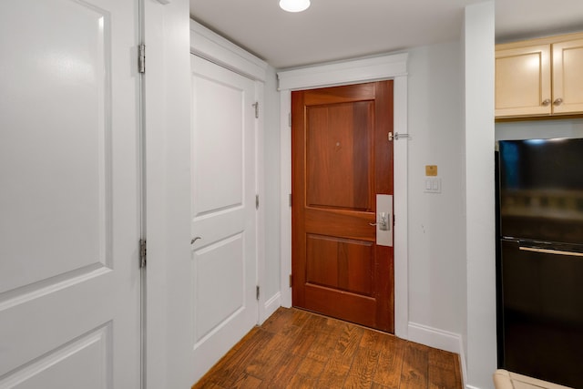 doorway to outside with dark wood-type flooring and baseboards