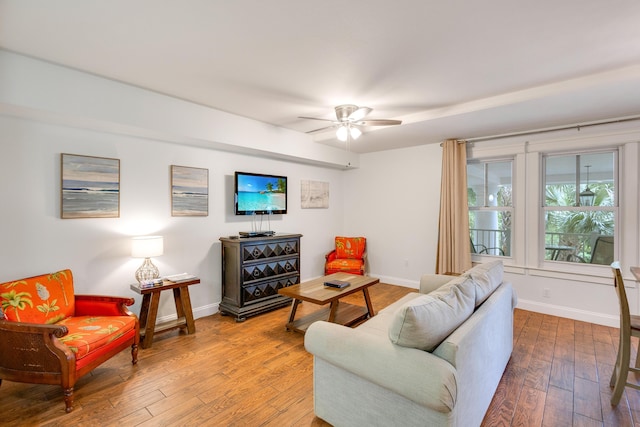 living room with a ceiling fan, baseboards, and hardwood / wood-style floors