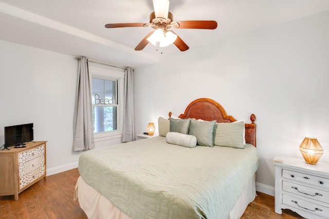bedroom featuring baseboards, wood finished floors, and a ceiling fan