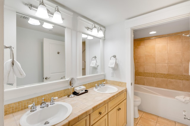 full bathroom with toilet, tile patterned floors, double vanity, and bathtub / shower combination
