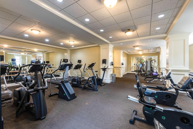 exercise room featuring ornate columns, a drop ceiling, and ornamental molding
