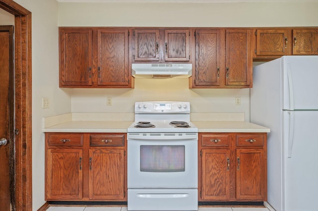 829 S Turnberry Cv, Niceville, FL 32578 - kitchen with under cabinet range hood, white appliances, light countertops, and light tile patterned floors